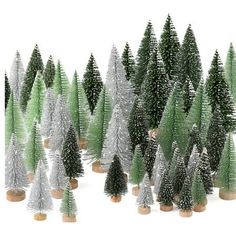 a group of small christmas trees with white and green tinsels on the tops