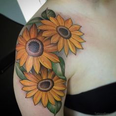 a woman's shoulder with sunflowers painted on it