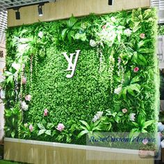 a green wall covered in plants and flowers