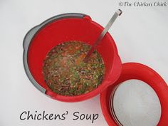 a red bowl filled with food sitting on top of a white table next to a strainer