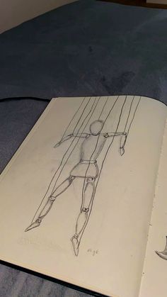 an open book with a drawing of a woman on it's cover and a pencil drawing of a human figure