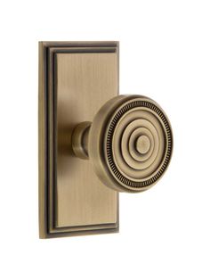 an antique brass door handle with a circular knob