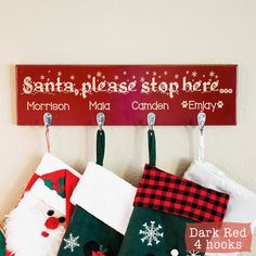 christmas stockings hanging from hooks with santa - please stop here sign