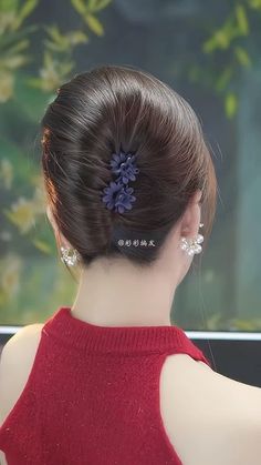 a woman wearing a red dress with a flower in her hair, looking out the window