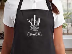 a woman wearing an apron with the word charlotte written on it and two hairbrushes in front of her