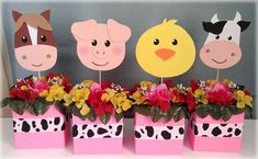 three farm animals are sitting on top of flowers in pink vases with yellow and red flowers