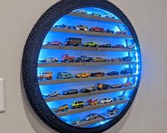 there is a round blue light in the wall with cars on it and shelves below