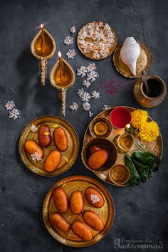 an overhead view of food on plates with candles, flowers and other items in the background