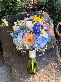 a bouquet of flowers sitting on top of a rock