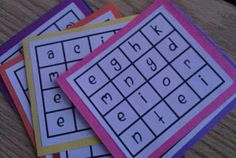 four cards with letters and numbers on them sitting on top of a wooden table next to each other