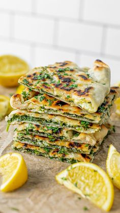 a stack of flatbreads with lemon slices and herbs