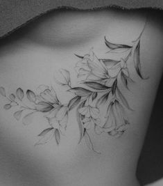 a black and white photo of a woman's back with flowers on her chest