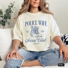 Show off your pride as a Law Enforcement spouse with this stylish Police Wife Social Club inspired shirt. Whether you're supporting your loved one through the academy or just want to show off your Officer pride, this shirt is perfect for you or as a gift for a fellow cop supporter. Add your location for a unique touch! P R O D U C T *  D E T A I L S🛍️ .: The Comfort Colors 1717 tee is made with medium fabric consisting of high quality, 100% ring-spun US cotton for long-lasting comfort. .: All C Cop Girlfriend, Police Wife Shirt, Police Officer Wife, Police Wife, Law Enforcement Officer, Cozy Fits, Social Club, Blue Line, Law Enforcement