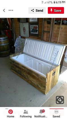 an open wooden box sitting on top of a cement floor next to barrels and other items