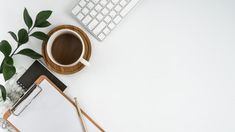 an overhead view of a desk with a keyboard, mouse and coffee cup on it