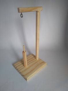 a small wooden stand with a handle on it's end and an object in the middle