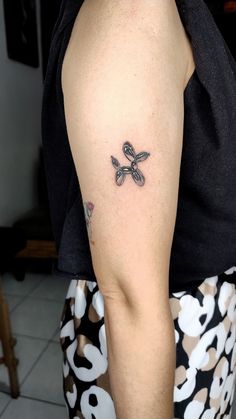 a woman's arm with a tattoo on it that has a bow in the middle