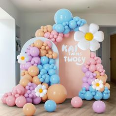 balloon arch with flowers and balloons on the floor