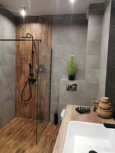 a bathroom with a sink, shower and wood flooring is shown in this image