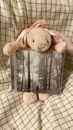 a teddy bear is holding an old photo