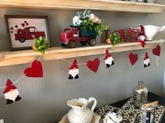 valentine's day decorations are displayed on shelves above a table