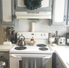 a white stove top oven sitting inside of a kitchen next to a microwave and toaster