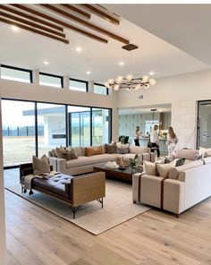 a living room filled with lots of furniture and large glass doors leading to an open floor plan