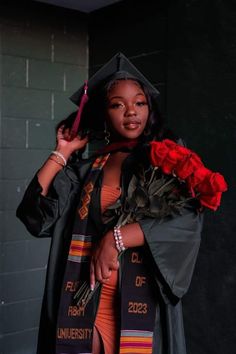 a woman wearing a graduation gown and holding a rose