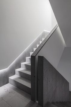 an empty staircase with concrete walls and steps