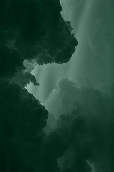 the sky is filled with dark clouds and green hues