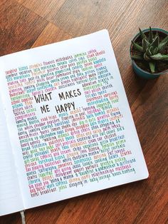 an open notebook with the words what makes me happy written on it next to a potted plant