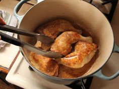 someone is cooking chicken in a pot on the stove