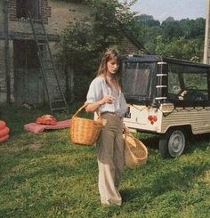 a woman holding a basket and standing next to a golf cart