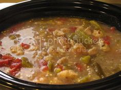 a black crock pot filled with soup and vegetables