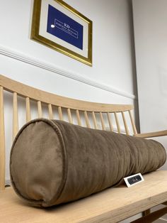 a brown pillow sitting on top of a wooden bench