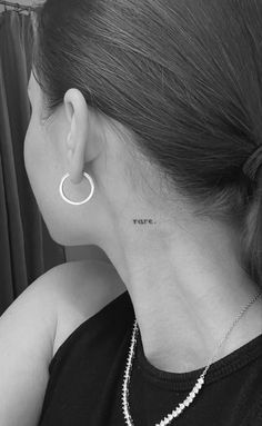 a woman with a small tattoo on her left side of her neck and behind her ear