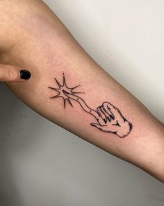 a woman's arm with a tattoo on it that has a hand holding a star