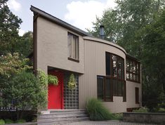 a red door sits in front of a modern house