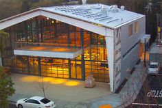 a white car is parked in front of a large building with glass doors and windows