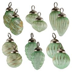 six green glass ornaments hanging from hooks