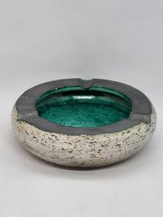 a green and white bowl sitting on top of a table