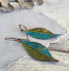 These hand painted copper leaf earrings are a unique and striking accessory that have been crafted in our island studio using a special house patina paint blend resulting in a beautiful blue green finish reminiscent of the Caribbean sea. Once the patina process is complete, we buff and seal the copper for durability and to prevent tarnishing. Each pair of earrings are one-of-a-kind, with variations in the patina that add to their handmade charm. Size: 2.25 Inches from Lobe Ear Wire: Choice of Antique Copper or Sterling Silver French Ear Hooks with Safety Back Lightweight and Comfortable Handmade in the USA Gift Ready: Your earrings come in a gift pouch ready for giving or to treasure for yourself. Green Hand Painted Copper Earrings, Hand Painted Green Copper Jewelry, Modern Hand Painted Green Copper Jewelry, Modern Green Hand Painted Copper Jewelry, Vintaj Jewelry, Patina Paint, Patina Copper, Earrings Nature, Copper Jewelry Handmade