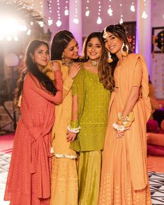 three women standing next to each other in dresses