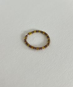 This is a simple, small ring made by stringing seed beads onto wire. Featuring brown and yellow beads, it's great for stacking with other rings.  Ring size approximately 8.5 Dainty Yellow Jewelry With Tiny Beads, Yellow Tiny Beads Round Jewelry, Beaded Toe Rings For Jewelry Making, Yellow Round Beaded Jewelry, Yellow Jewelry With Tiny Round Beads, Seed Bead Ring, Small Ring, Beaded Ring, Small Rings