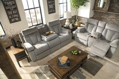 a living room with two couches and a coffee table in front of windows on the wall