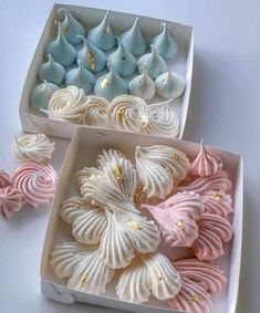 two white boxes filled with pink and blue cupcakes