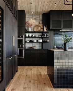 a kitchen with wooden floors and black cabinets