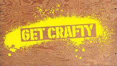 the word get crafty painted on wood with yellow paint splattered over it