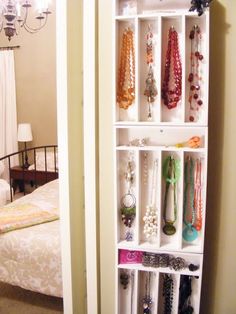 a white shelf filled with lots of necklaces