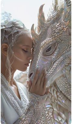 a woman is kissing the face of a dragon